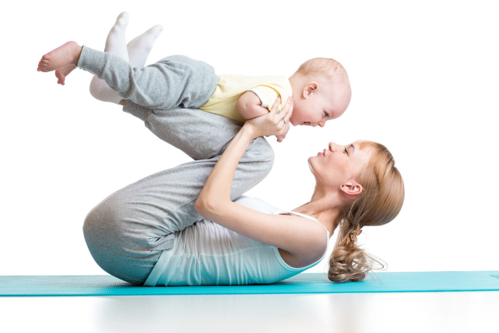 young mother does fitness exercises together with baby boy